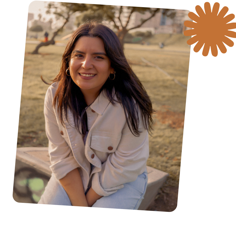Portrait of a man with brown hair and glasses on a flat gray background.
